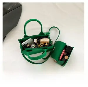 Internal capacity of green felt handbag showing smartphone and cosmetics storage