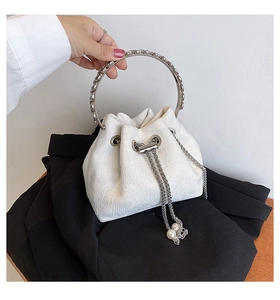 Detail of white lace bucket bag with silver metal handle and pearl drawstring charms