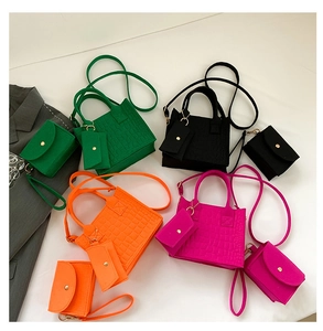 Detailed view of crocodile pattern felt bag set in green, black, orange, and rose red