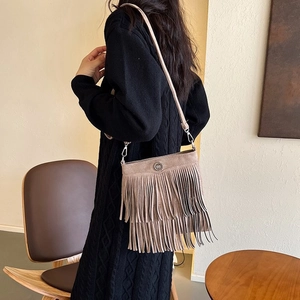 Detail of bohemian khaki suede bucket bag with multi-layer fringes and metallic logo