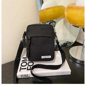 Detailed view of black canvas crossbody bag with Fashion label on books