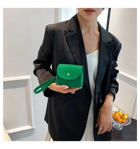 Close-up of bright green mini felt pouch with gold buckle and matching hand strap