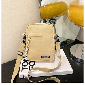 Detail of minimalist beige canvas crossbody phone bag featuring a Fashion woven label