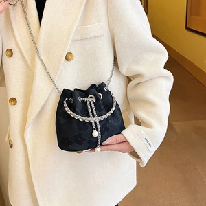 Minimalist black jacquard bucket bag with floral pattern and elegant silver chain
