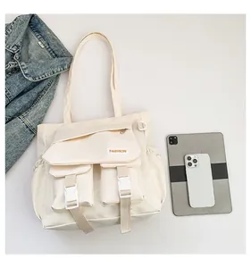 Makroaufnahme der cremefarbenen Nylontasche mit Funktionstaschen im Vergleich zum Tablet und Handy