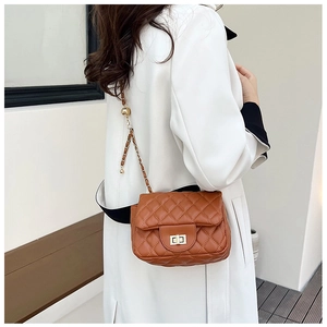 Detailansicht braune Stepptasche mit goldener Kette und elegantem Drehverschluss