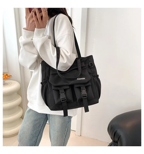 Detail der schwarzen Nylon-Tasche mit Kunststoffschnallen und Seitentasche mit Kordelzug