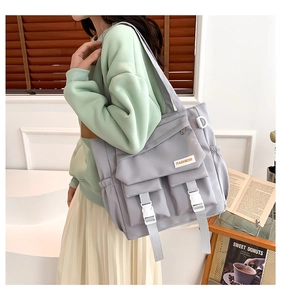 Detailansicht der grauen Nylon-Einkaufstasche mit Utility-Taschen und Schnallenriemen