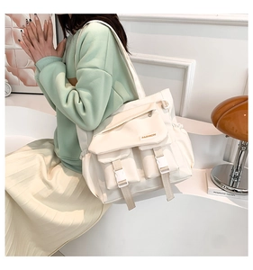Detail der cremefarbenen Nylontasche mit Funktionstaschen, Schnallen und Kordelzug-Design
