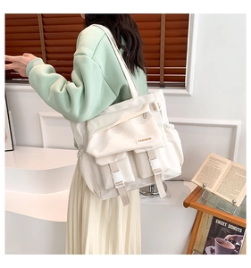 Detailansicht der großen cremefarbenen Nylontasche mit Multi-Pocket-Design und Schnallen