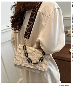 Détail du sac en paille avec broderies florales et large bandoulière à motifs