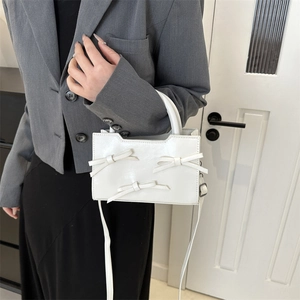Sac à main blanc brillant avec nœuds décoratifs et bandoulière pour femme élégante