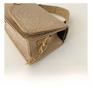 Close-up of golden glitter handbag details with shiny metallic chain hooks and side d-rings