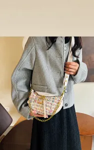 Detail of the colorful tweed fabric and metal chain strap on this stylish crossbody bag