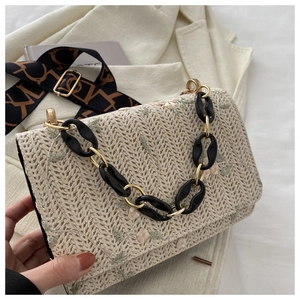 Détail de broderie florale sur sac bandoulière tissé avec poignée en chaîne acrylique