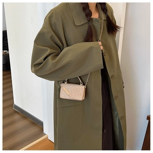 Mini champagne gold sequin crossbody bag styled with an olive green trench coat