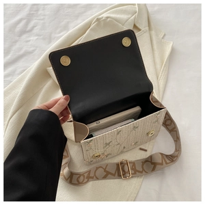 Détail intérieur du sac en paille avec broderie florale et large bandoulière géométrique