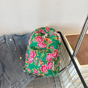 Detailed close-up of a green floral backpack with peony pattern in a metal basket