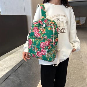 Close-up of vibrant floral canvas backpack with red peony pattern and white straps