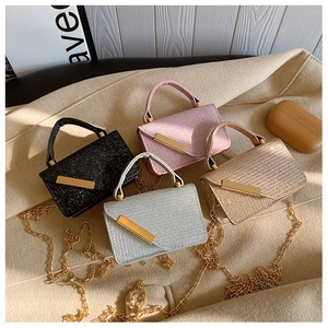 Detail of glitter mini crossbody bags in four colors with gold metal chains and buckles