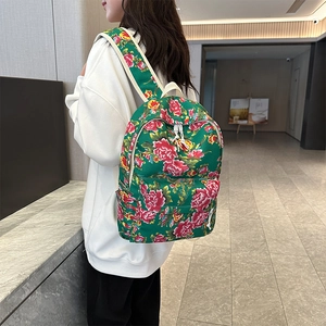 Detail view of ethnic floral backpack featuring green canvas with peony patterns