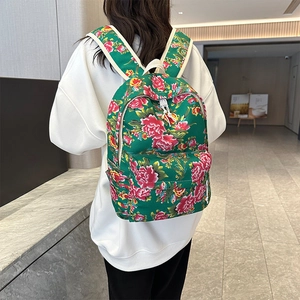 Floral print backpack with red peony pattern shown on model in a casual setting