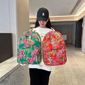 Detail showing two floral pattern backpacks in red and green colors with traditional prints