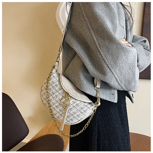 Detail of tweed crossbody bag with golden chain and round metal hardware ornament