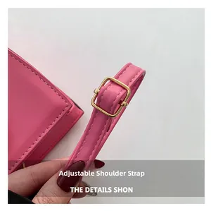 Détail du sac rose avec bandoulière réglable, boucle dorée et fines coutures blanches