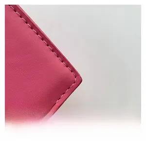 Gros plan sur le cuir rose avec coutures de précision sur un petit sac à main carré