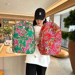 Detail view of red and green floral canvas backpacks with traditional peony patterns