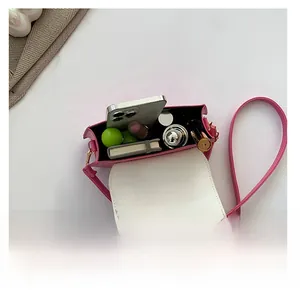 Petit sac à bandoulière rose montrant la capacité pour téléphone et maquillage