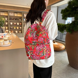 Detailed view of large red peony pattern backpack with white zipper accents