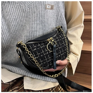 Detailed macro view of the black tweed dumpling bag with golden chain and long leather tassel
