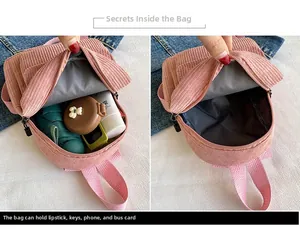Pink corduroy mini backpack interior detail showing storage for phone and cosmetics