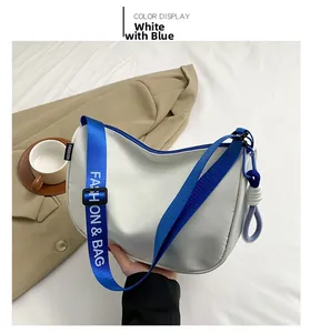Detail of white shoulder bag with blue strap featuring Fashion & Bag text and knot