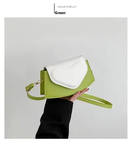 Vue détaillée d'un sac bandoulière vert et blanc en forme de cœur avec bandoulière