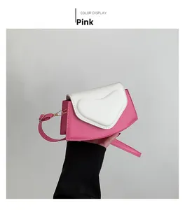 Détail du sac bandoulière rose avec gaufrage en forme de cœur et sangle réglable