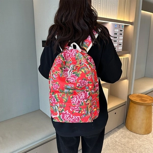 Close-up of red backpack with traditional Chinese peony pattern and white straps