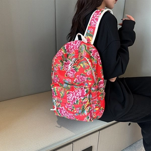 Detail view of the red floral canvas backpack featuring traditional peony patterns