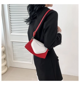 Détail du sac à rabat en forme de cœur rouge et blanc avec bandoulière en cuir réglable