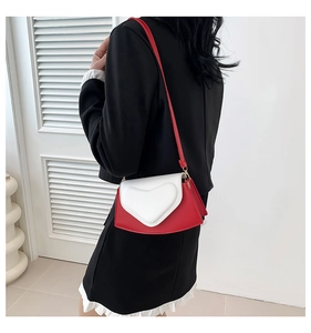Vue détaillée du sac bandoulière cœur rouge et blanc avec boucles métalliques dorées
