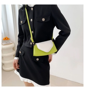 Détail du petit sac carré vert néon et blanc avec des accessoires en métal doré