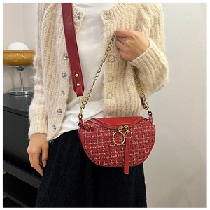 Detail of red tweed crescent crossbody bag with gold chain strap and large ring zipper