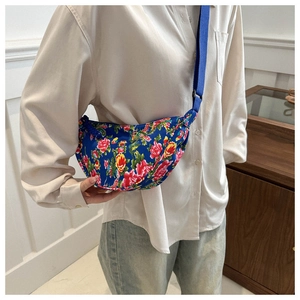 Detail of crossbody crescent bag with traditional Chinese floral pattern and blue strap