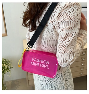 Detail of rose pink transparent PVC jelly bag with white fashion lettering and yellow strap
