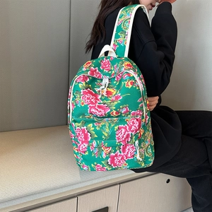 Side view of a vintage floral backpack with pink peonies on a green background