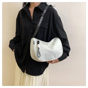 Detail of white crescent crossbody bag featuring an adjustable branded letter strap