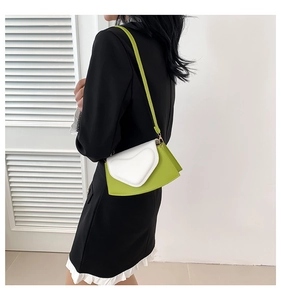 Détail du petit sac bandoulière bicolore en forme de cœur avec boucle dorée et bandoulière