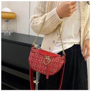 Detail of red tweed dumpling bag showing golden chain and wide leather shoulder strap